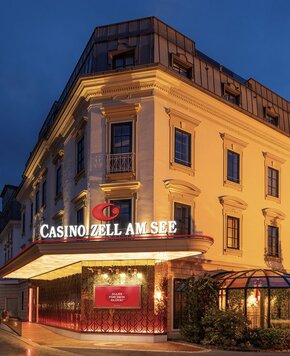 Das beleuchtete Casino Zell am See befindet sich an der Ecke eines historischen Gebäudes neben dem GRAND HOTEL.