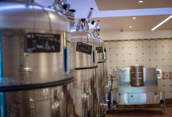 Mehrere Edelstahl-Braukessel stehen in der Hausbrauerei von Pinzga Bräu.