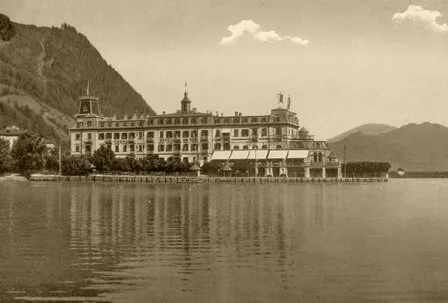 Das Grand Hotel Zell am See liegt direkt am Ufer des Zeller Sees und spiegelt sich im ruhigen Wasser.