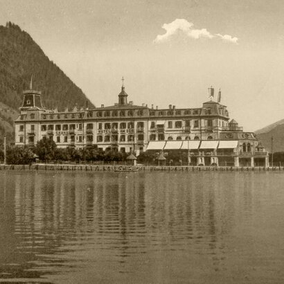 Das Grand Hotel Zell am See liegt direkt am Ufer des Zeller Sees und spiegelt sich im ruhigen Wasser.