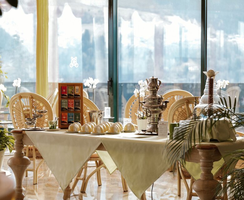 Ein gedeckter Tisch in einer hellen Wellness-Lounge mit Blick durch große Fenster.