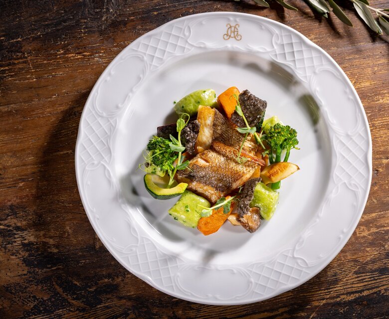 Sommerliches Fischgericht auf weißem Teller im Grand Hotel Zell am See