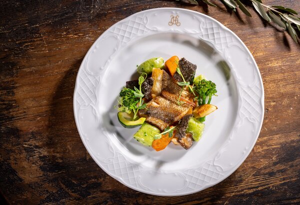 Sommerliches Fischgericht auf weißem Teller im Grand Hotel Zell am See