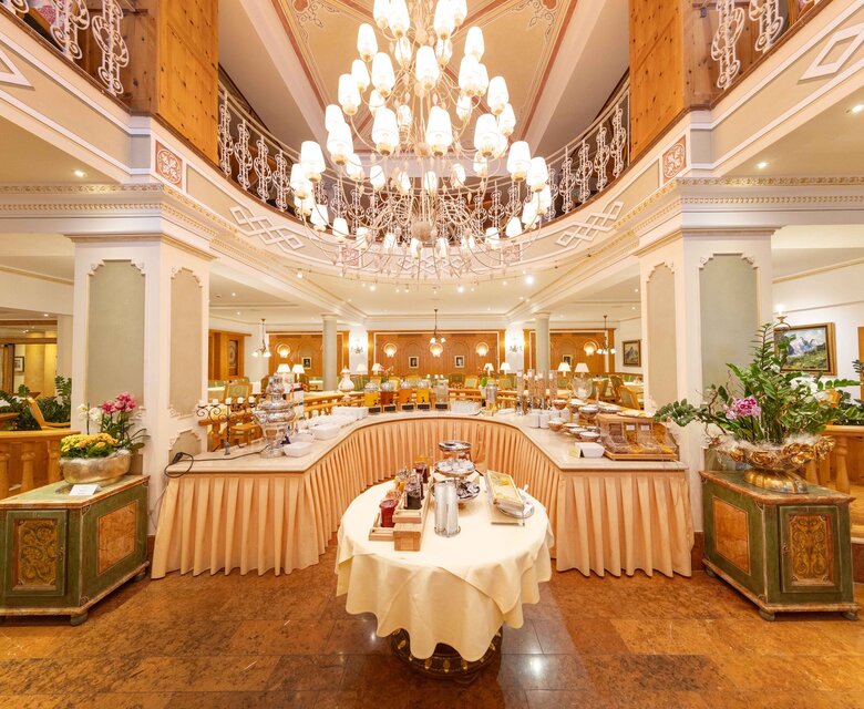 Ein großzügiges Buffet im hellen Hotelrestaurant mit gedecktem Tisch und Kronleuchter im GRAND HOTEL Zell am See.