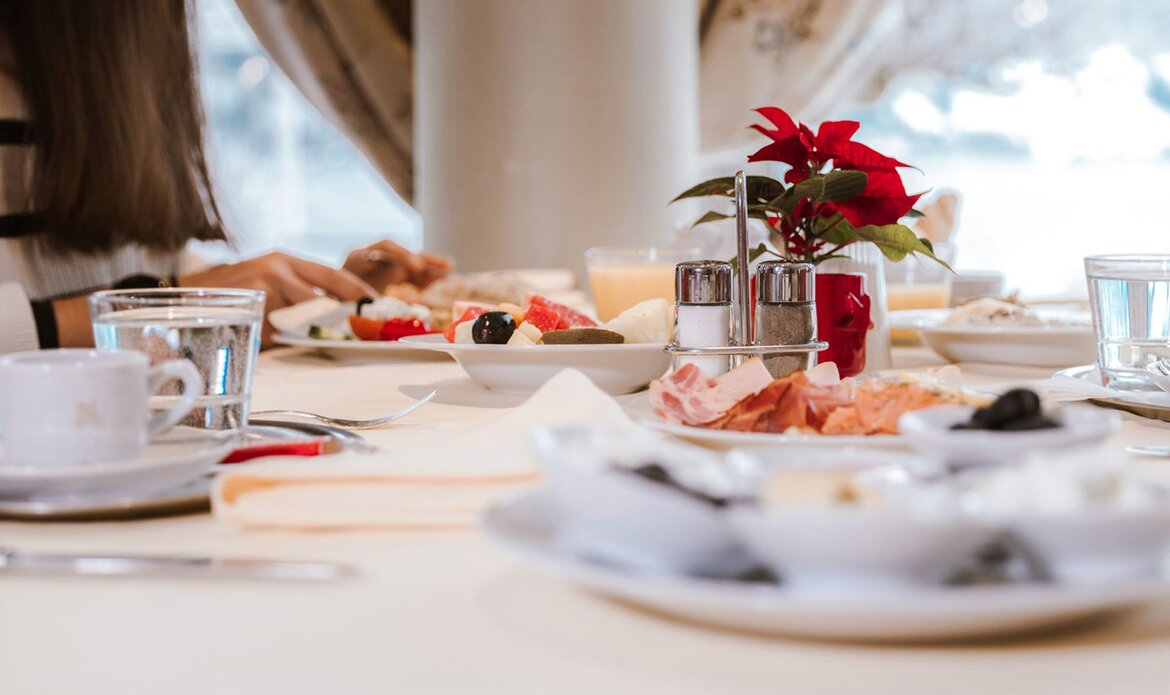 Ein gedeckter Frühstückstisch mit Gebäck, Obst und Getränken im GRAND HOTEL Zell am See.
