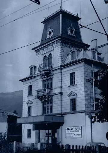 Das historische Grand Hotel mit markantem Dachturm und Fassade steht an einer Straße in Zell am See.