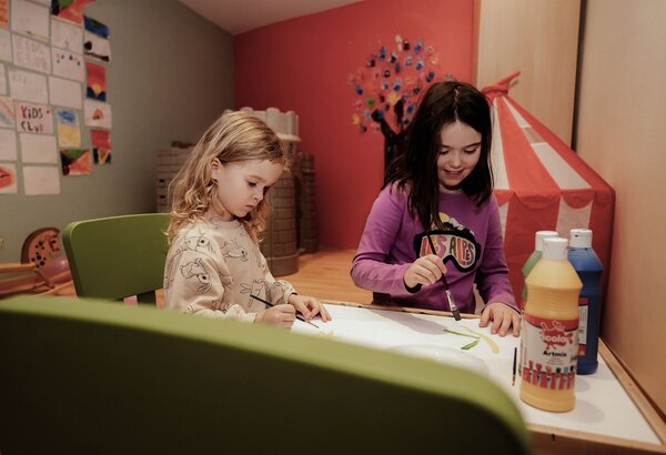 Zwei Kinder malen an einem Tisch im ruhigen Kinderbereich des Family Spa.