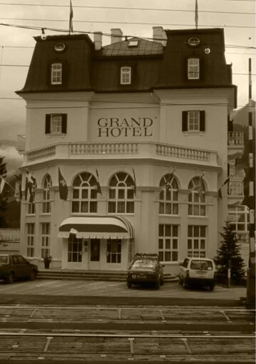 Das historische GRAND HOTEL Zell am See mit Fassade, Mansarddach und Eingangsbereich an der Straßenseite.